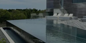 Custom infinity pool with sleek design and modern outdoor seating, showcasing luxury landscape and masonry elements in New York.