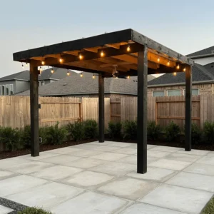 Modern patio pergola with string lights, surrounded by a landscaped yard and concrete pavers, showcasing outdoor design inspiration for luxury living.