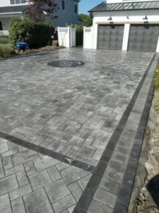 Paved driveway featuring intricate masonry design and circular pattern, showcasing Soft Wind Landscape & Masonry's expertise in outdoor transformations in New York.